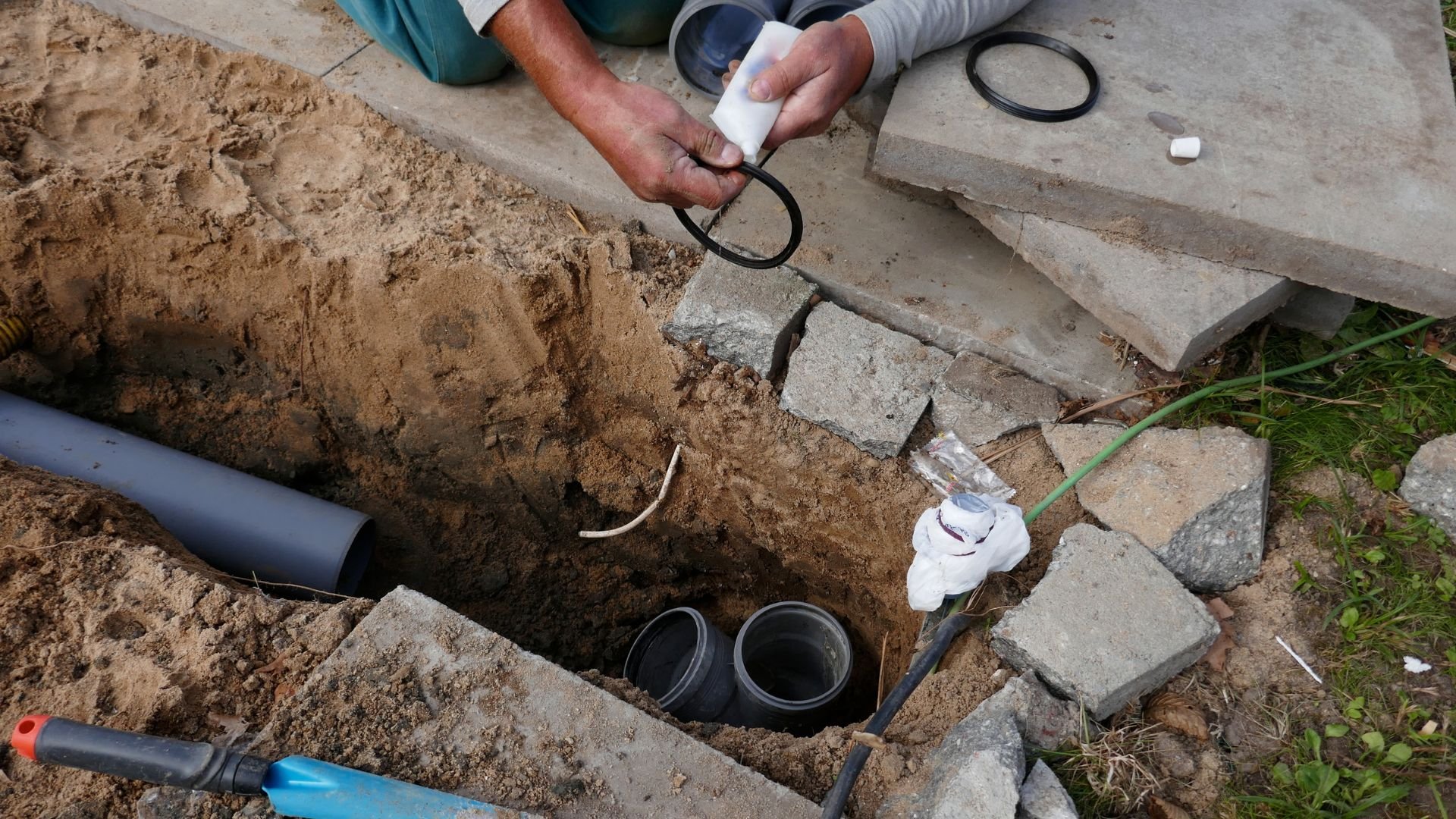 Workers installing underground pipes and connecting drainage system components